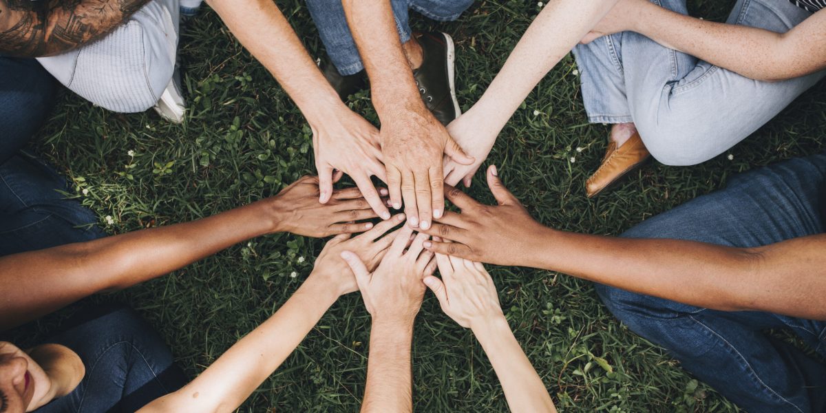 People stacking hands together in the park